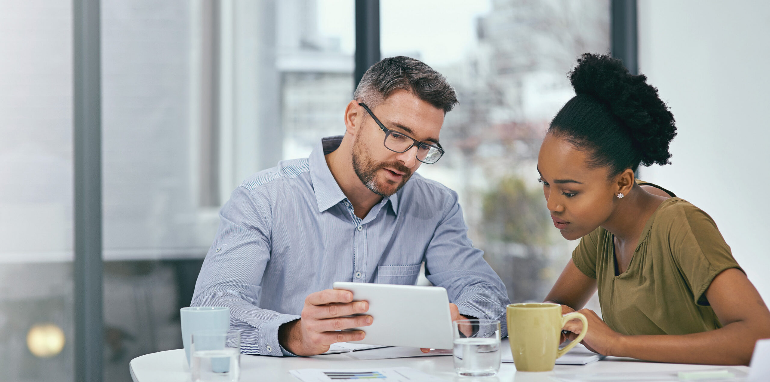 A man and woman look at a tablet together
