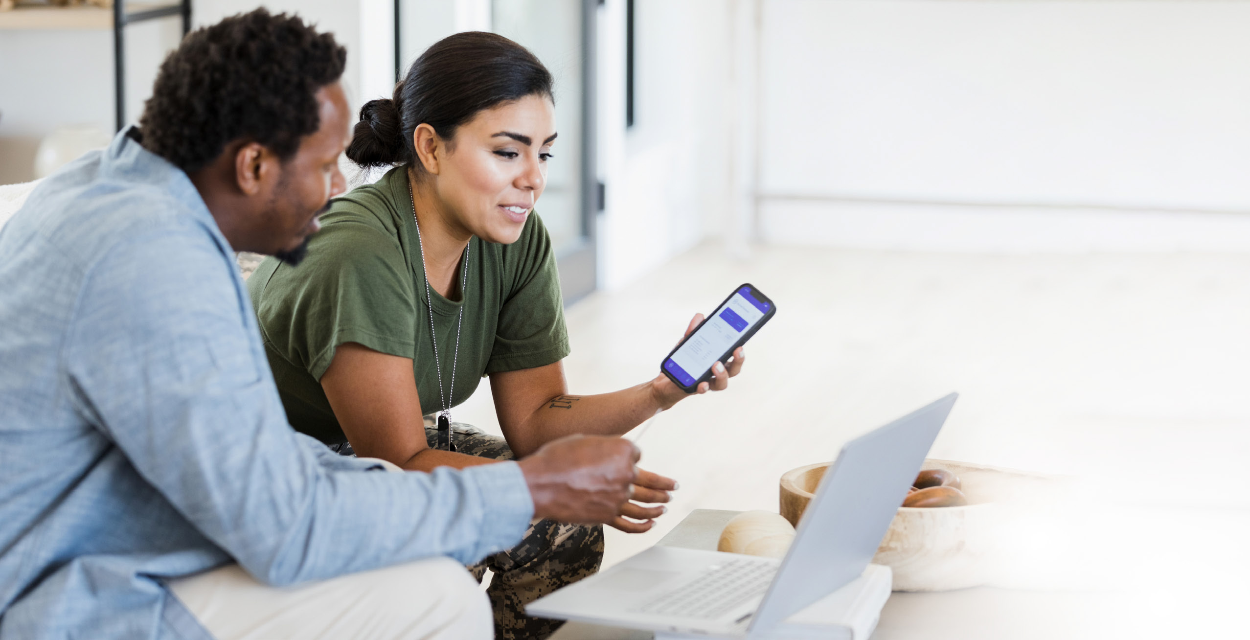 A man and woman look at a phone together