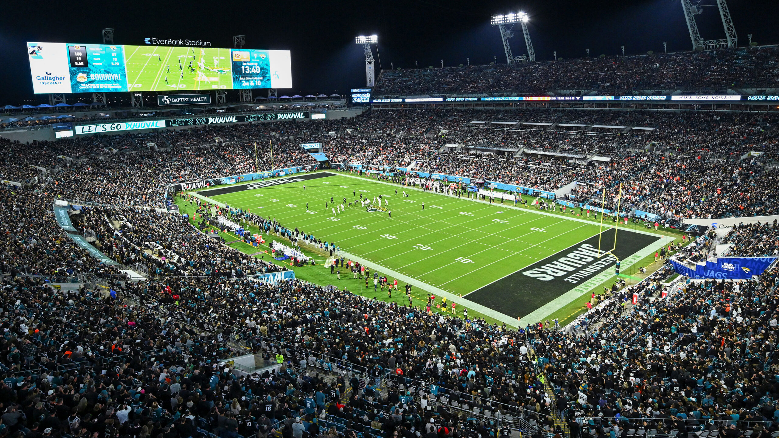 Jacksonville Jaguars field at night with audience and players, with a green turf grass.